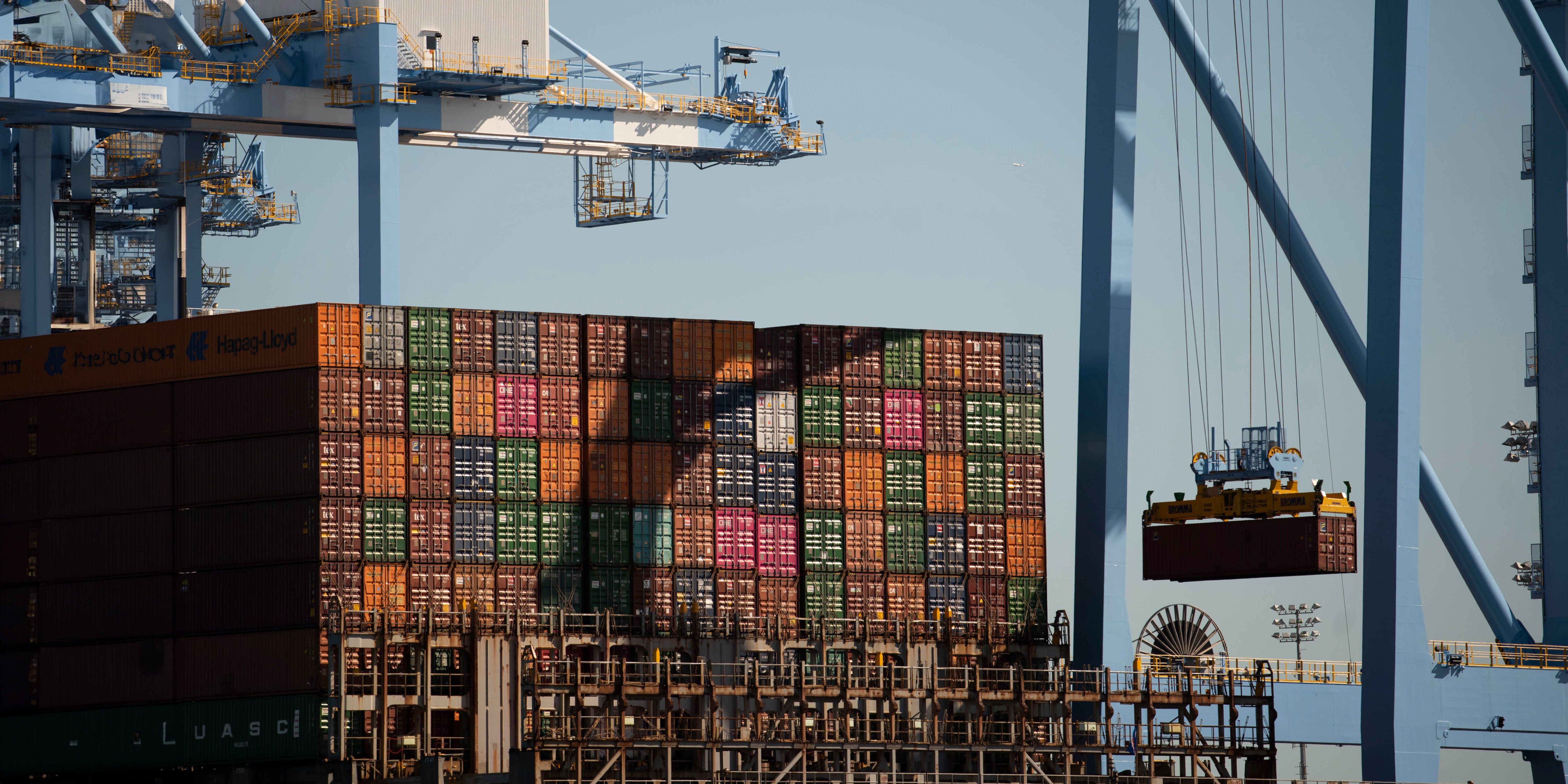 Cranes lifting containers from a ship.