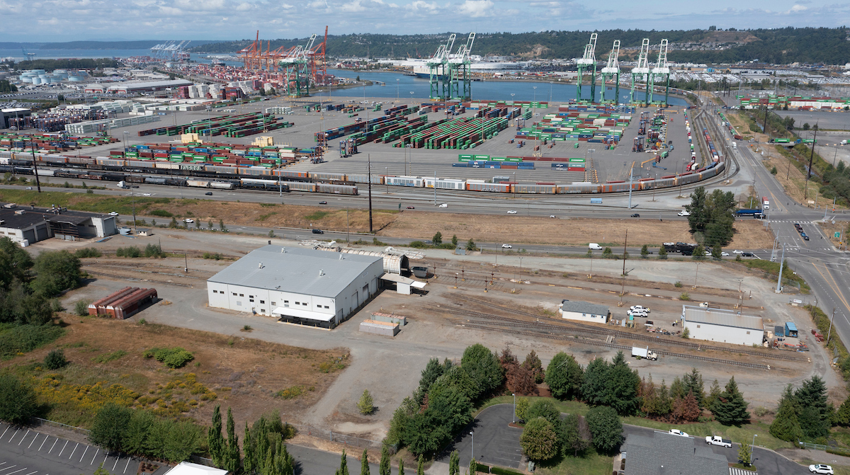 An aerial shot with a large white single story building next to a terminal.