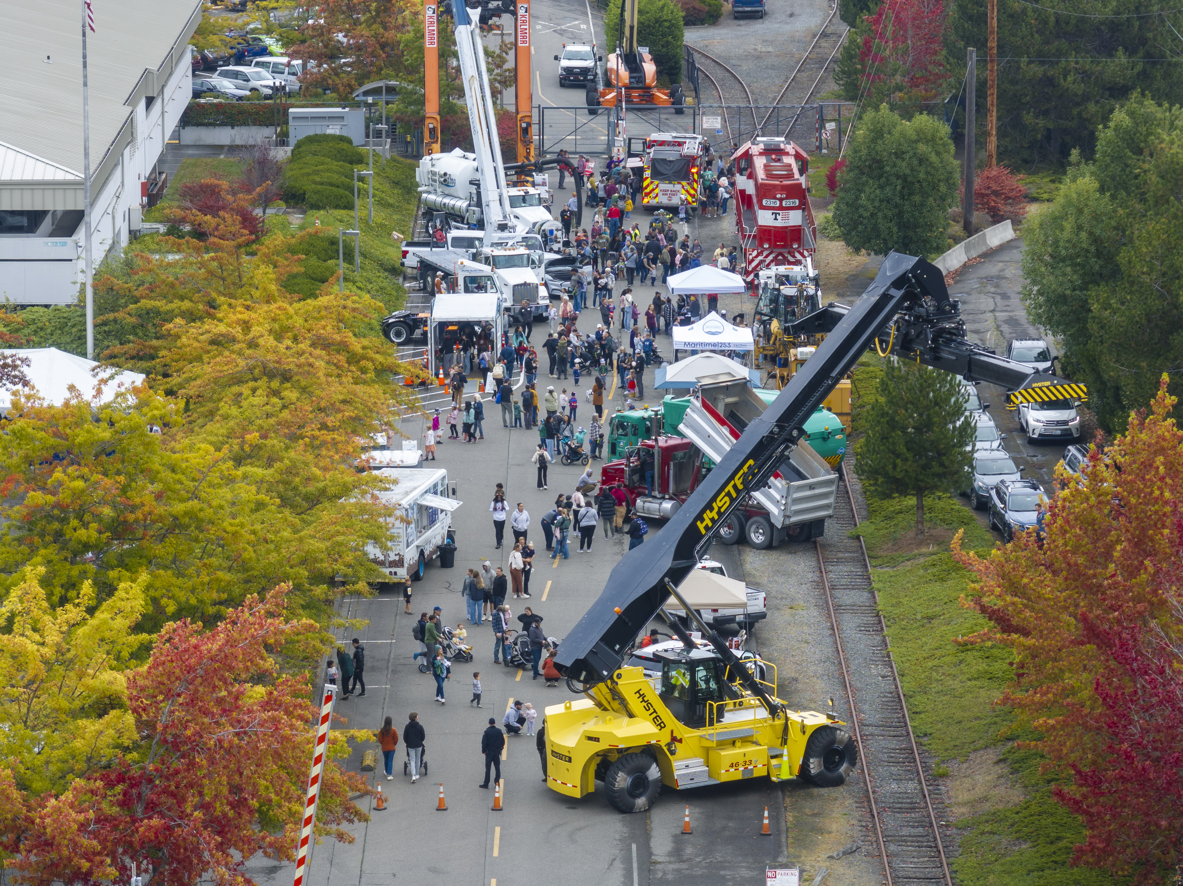 Overhead shot of a street lined with people and construction vehicles.
