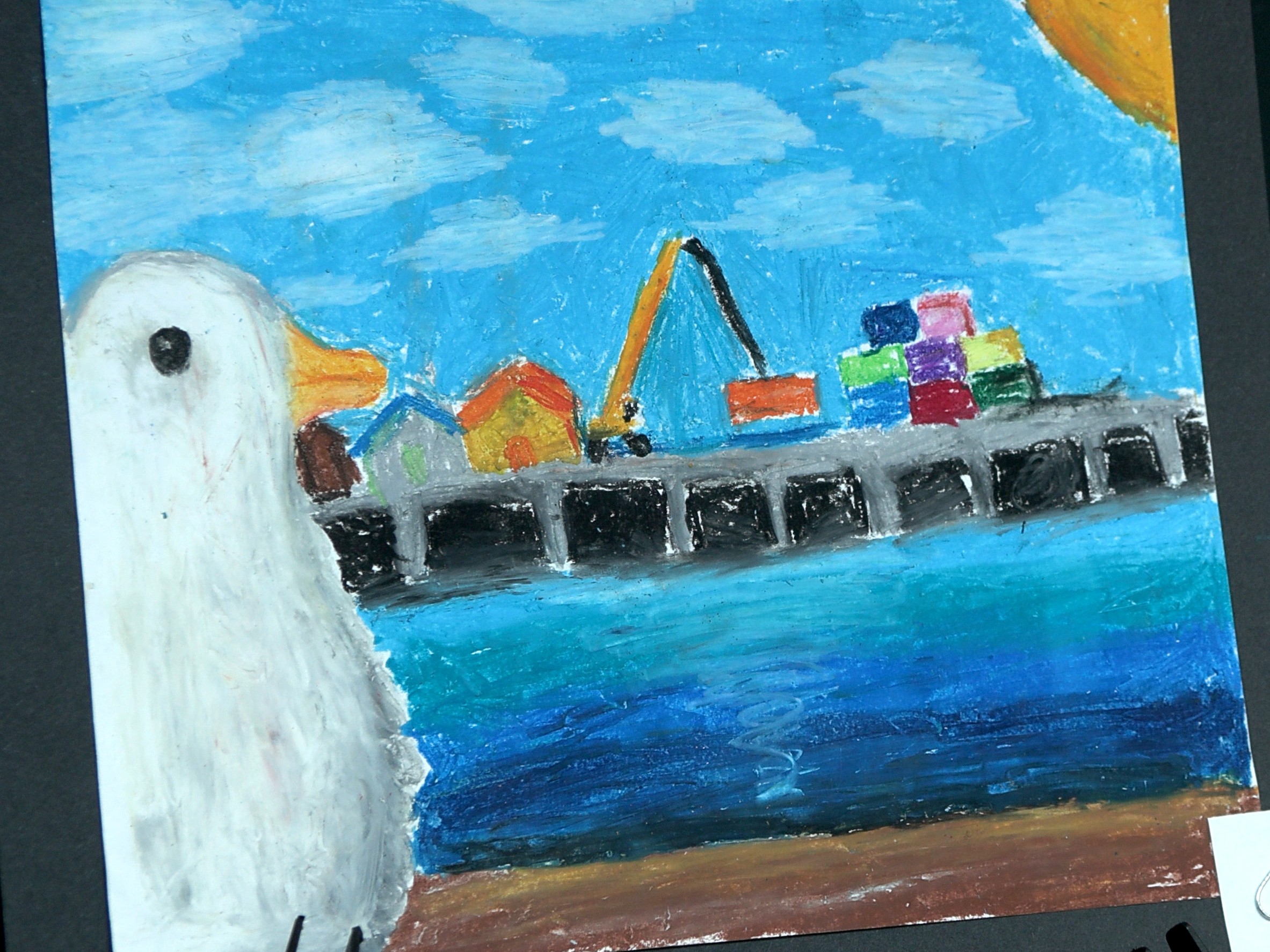 Student-created art of a seagull in front of a Port terminal and waterway.