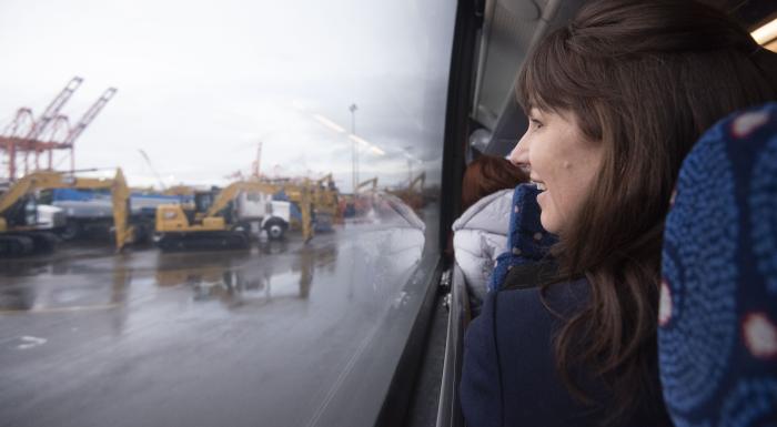 A woman looking out the window of a bus while on a tour. 