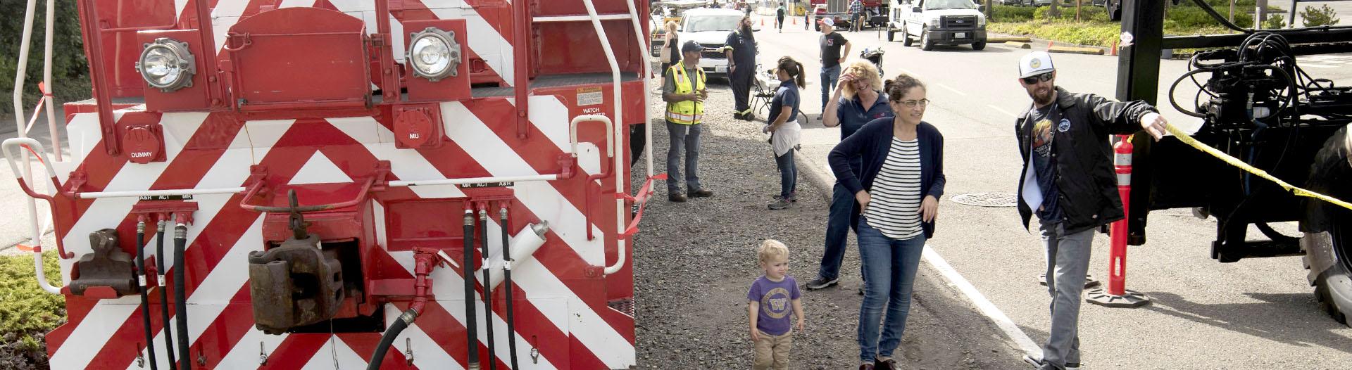 People walking around a Tacoma Rail engine. 