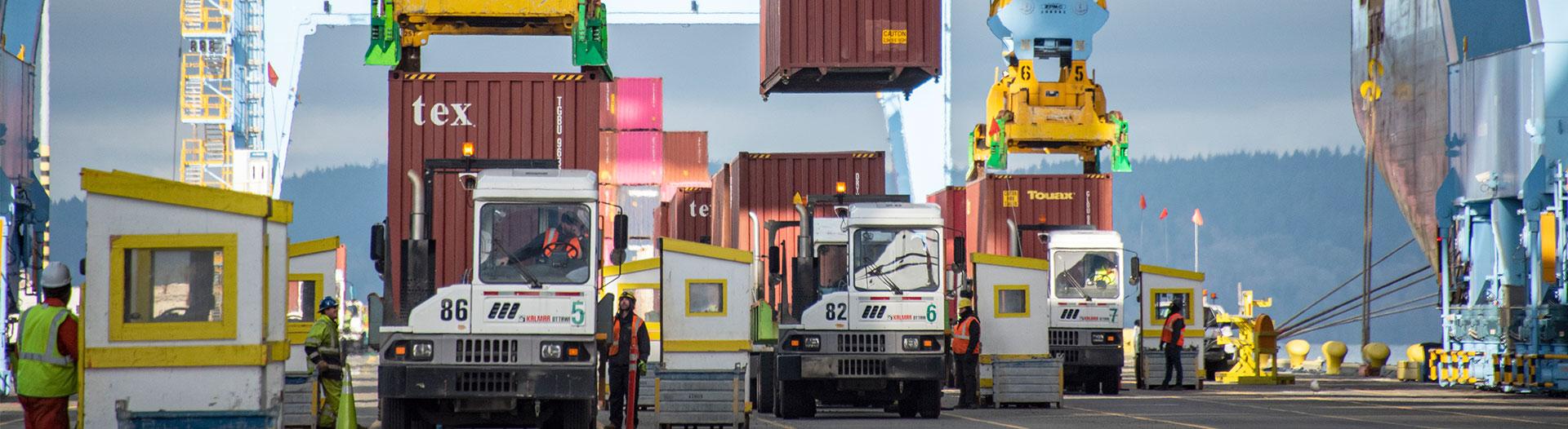 a photo of crane lifting containers from truck