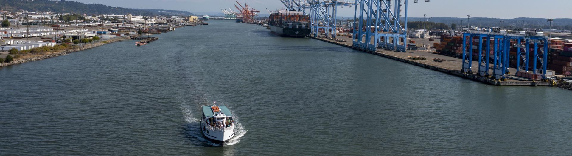 Aerial shot of a boat moving through a port waterway.