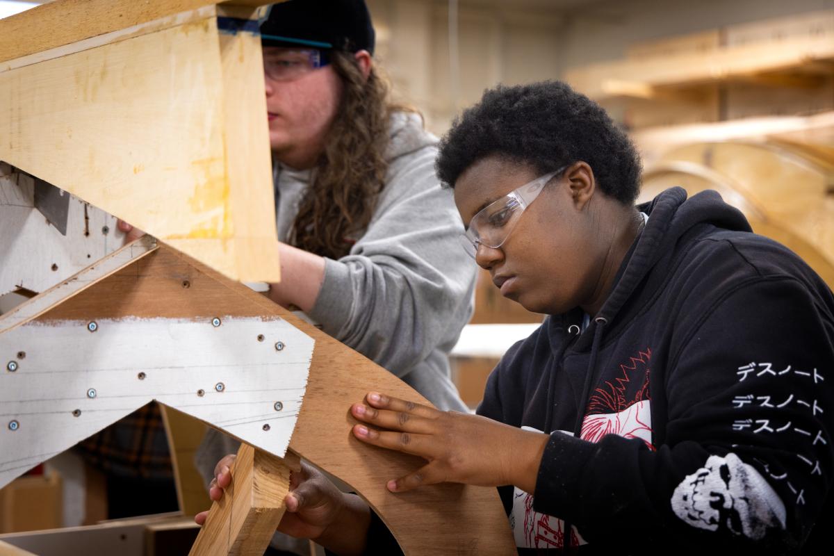 Students learning boat building techniques.