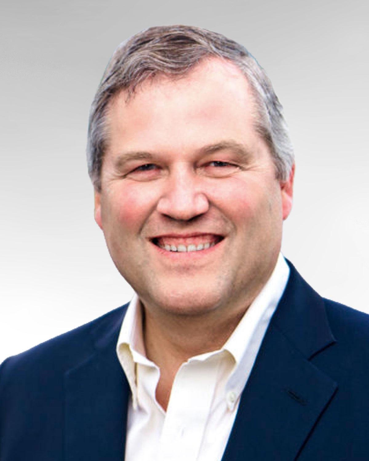 Headshot of Commissioner JT Wilcox, a man with gray hair in a white shirt and blue sport coat