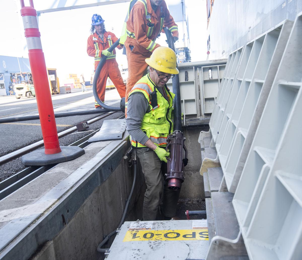 A worker plugs in a ship at berth.
