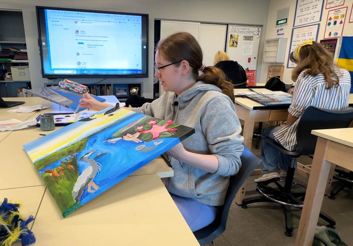 A student holds the art they created inspired by Port of Tacoma.